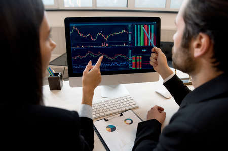 Business colleagues, co-founders the company, managers, stock market traders, sitting at desktop in...