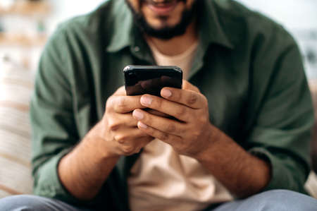 Close-up of a smartphone in a male hands. The concept of online messaging, social media...