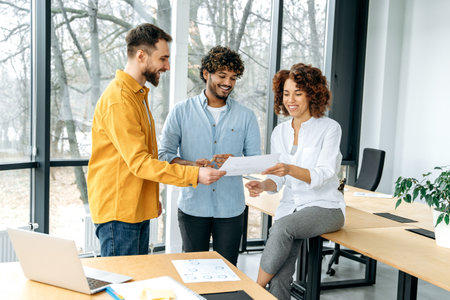 A group of multiracial business people, colleagues at work, looking through documents in a modern...