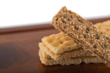 Brown and creamy crispbreads on wooden table