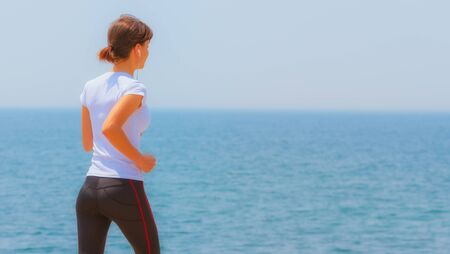Runner girl - athlete running at seaside in summer, woman fitness, healthy lifestyleの写真素材