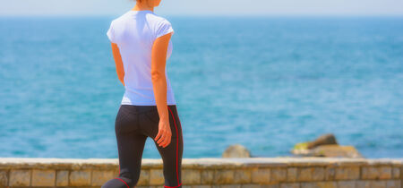 Runner girl - athlete running at seaside in summer, woman fitness, healthy lifestyleの写真素材