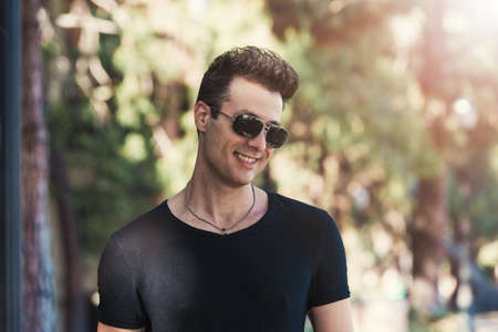 Stylish smiling man with sunglass looking away.の写真素材