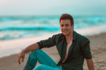 Casual and smiling man relaxing at beach.