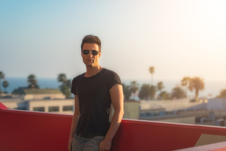 Handsome sexy and serious man looking from the building roof.
