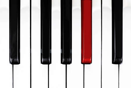 Close up of black, white and one red piano keysの写真素材