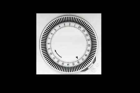 Close up of white electric timer isolated on black background