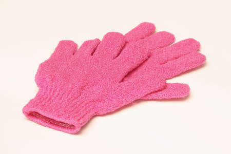Close up of pink gloves for removing dead skin cells  isolated on white backgroundの写真素材
