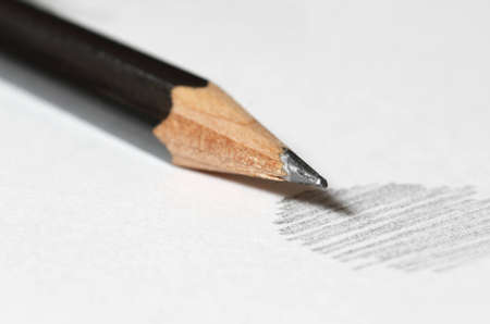 Close up of black graphite pencil on the top of white paper with abstract sketchingの写真素材