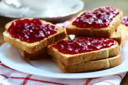 Sandwiches with white bread spread with homemade cherry jamの写真素材
