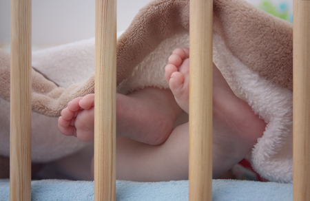 Close up of bare baby feet in bedの写真素材