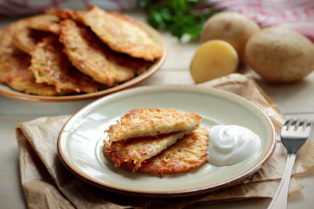 Fried crispy hash browns served on a plate placed on wooden backgroundの写真素材