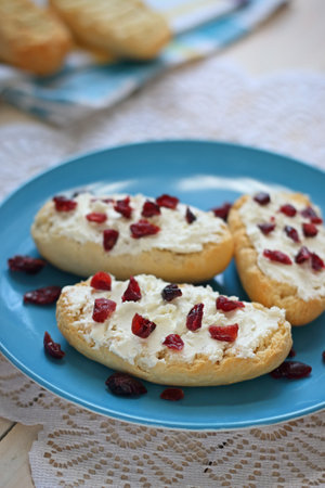 Bruschetta with cottage cheese and dried cranberries over light wooden backgroundの写真素材