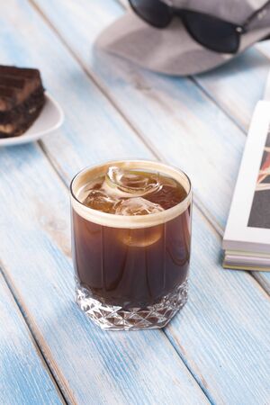 Tasty fresh cold iced espresso  in glass on blue table