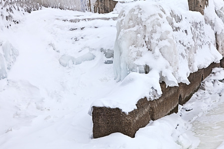 winter berth at the quay of the river covered with ice and snow