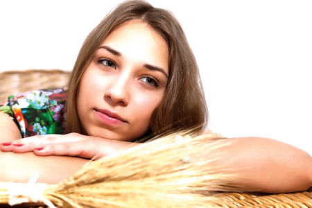 women laid her head on her hands isolated on white background with stalks of wheatの写真素材