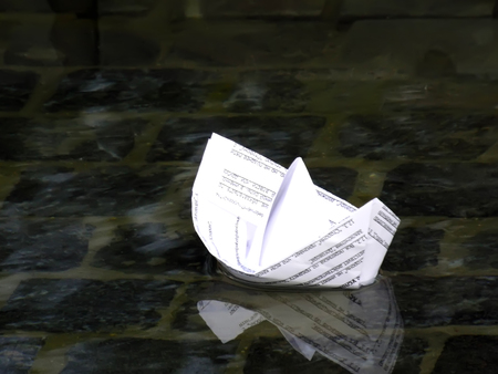 Ship folded from paper floating on the waterの写真素材