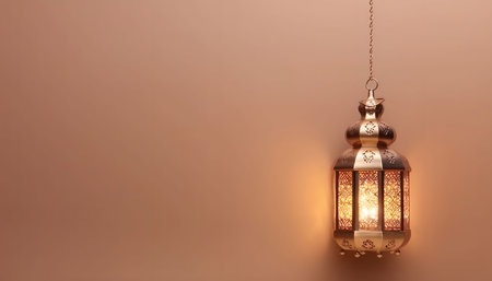 A golden Ramadan lantern hangs from a chain against a warm brown background, glowing with a warm light. The lantern is adorned with intricate patterns, symbolizing the beauty and spirit of Ramadan.の写真素材