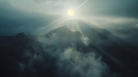 Sun rays pierce through misty mountains, creating a serene and peaceful atmosphere. An aerial shot capturing nature's beauty.の写真素材