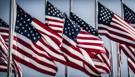A row of American flags waving proudly in the wind, symbolizing freedom, patriotism, and the spirit of America.の写真素材