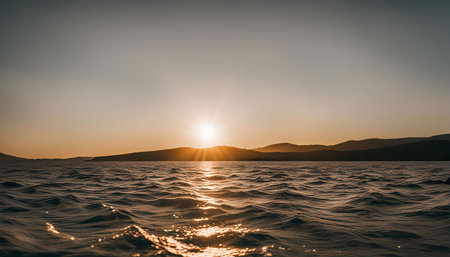 A breathtaking sunset over a calm body of water. The golden light of the sun reflects on the waves, creating a serene and peaceful atmosphere.の写真素材