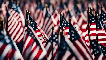 A close-up view of a field of American flags waving in the wind. The flags are arranged in rows, creating a colorful and patriotic display. The flags symbolize the values and history of the United States.の写真素材