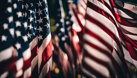 A close-up image of multiple American flags waving in the wind, highlighting the vibrant red, white,...