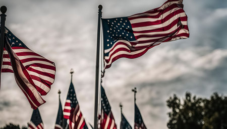 Several American flags wave proudly in the wind against a cloudy sky. A symbol of freedom and patriotism.の写真素材
