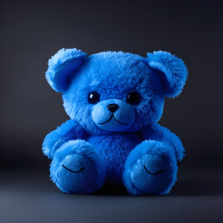 A captivating image of a blue plush teddy bear sitting against a dark background. The soft lighting emphasizes the toy's fluffy texture and cute expression.の写真素材