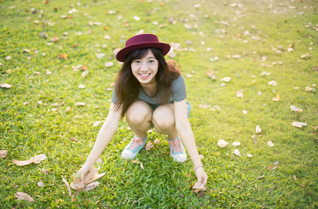 Woman relaxing in park enjoying her freedom wear short dress,Woman smiling happy freedom with sunlightの写真素材