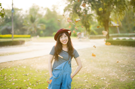 Woman relaxing in park enjoying her freedom wear short dress,Woman smiling happy freedom with sunlightの写真素材