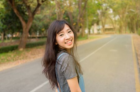 Portrait of cute young woman smiling relaxing in park enjoying her freedom wear short dressの写真素材