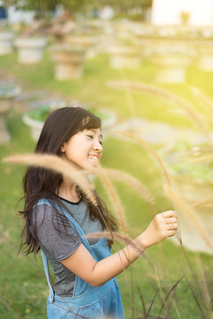 Portrait of cute young woman smiling relaxing in park enjoying her freedom wear short dressの写真素材