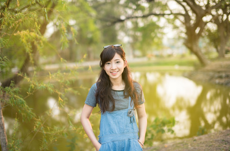 Portrait of happy woman relaxing in parkの写真素材