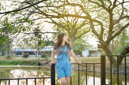 Portrait of cute young woman smiling relaxing in park enjoying her freedom wear short dressの写真素材