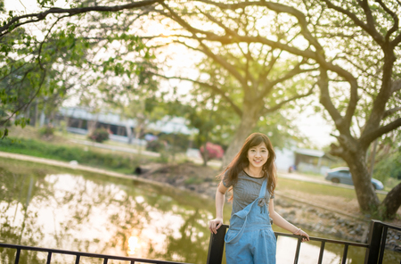 Portrait of cute young woman smiling relaxing in park enjoying her freedom wear short dressの写真素材