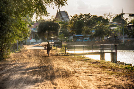 Farmer walking home after the harvest is completed with sunlightの写真素材