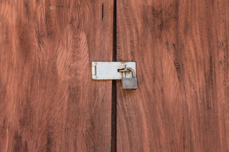 Vintage brown wooden locked door with old door knobの写真素材