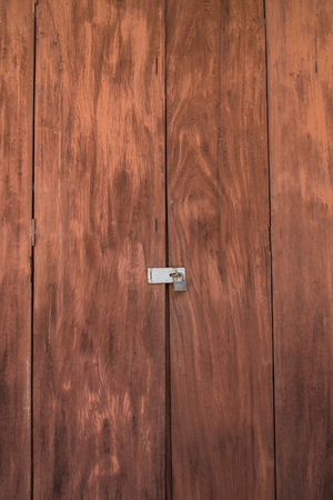 Vintage brown wooden locked door with old door knobの写真素材