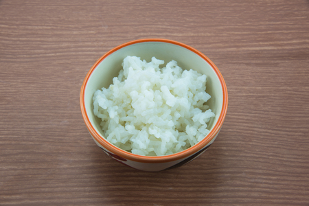 White rice in blow on wood backgroundの写真素材
