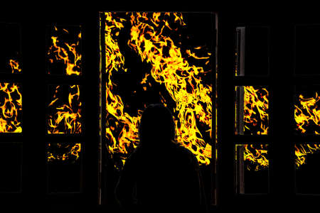 Silhouette young woman in the hotel, looking fire through the windowの写真素材