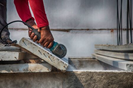 Builder worker with grinder machine cutting concreate floor at construction siteの写真素材