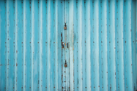 Mettalic lock without the key on the blue vintage door,Residential mettalic folding door with blue locking device installedの写真素材
