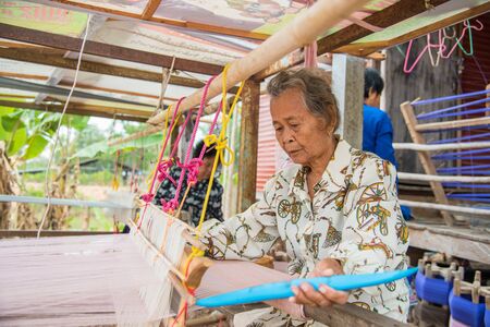 Nadun,Maha Sarakham,Thailand - March 9, 2018: Women weaving traditional thai fabric at Thailand. in Nadun,Maha Sarakham,Thailandのeditorial素材