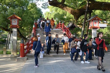 Fukuoka, JAPAN - 15 October 2019 : Tourists walking along the bridge. Arched bridge and historic shrine, Red bridge in Dazaifu Tenmangu, Fukuoka, Kyushu, Japan.のeditorial素材