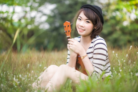 Girl with Ukulele in park-outdoor retro styleの写真素材