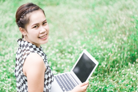 student girl with laptop studying in park の写真素材