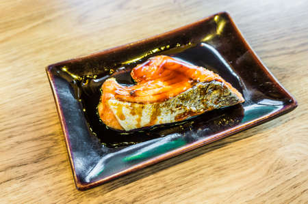 salmon steaks in the dish on wood tableの写真素材