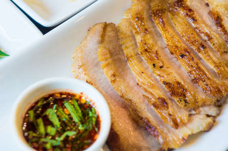 Pork neck grilled steak with spicy sauce and vegetable, close upの写真素材