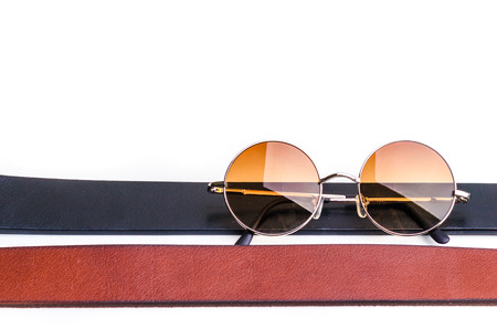 Brown leather belt for men and vintage glasses isolated on whiteの写真素材
